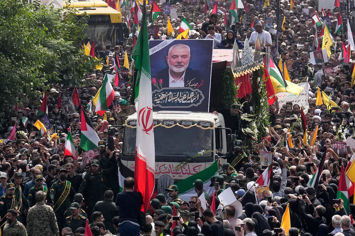 Iraníes siguen el jueves 1 de agosto de 2024 un camión que lleva los ataúdes del dirigente político de Hamás, Ismail Haniyeh, y su guardaespaldas, que fueron asesinados en un ataque que ha sido atribuido a Israel y que fue perpetrado en la víspera, durante su funeral en Teherán, Irán. (AP Foto/Vahid Salemi)