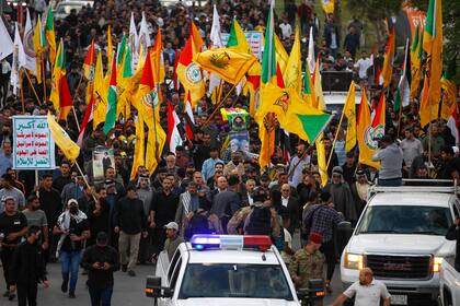 Iraquíes llevan el ataúd de Fadel al-Maksusi, un combatiente de Kataeb Hezbollah que también formó parte de la “Resistencia Islámica en Irak”, el grupo que se ha atribuido todos los ataques recientes contra las tropas estadounidenses en Irak y Siria, durante un funeral en Bagdad el 21 de noviembre de 2023.