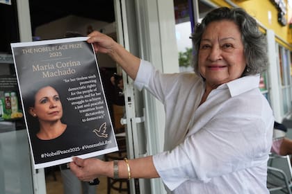 Iris Wilthew sostiene un cartel en apoyo a la líder opositora venezolana María Corina Machado tras recibir el Premio Nobel de la Paz, en Doral, Florida