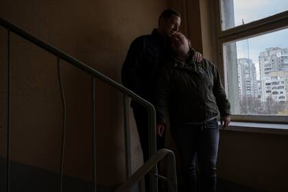 Iryna y Volodymyr, desplazados internos de Irpin, se apoyan el uno en el otro, en un descanso de la escalera cerca del apartamento donde se refugiaron con otros cuatro adultos de Irpin, en Leópolis, Ucrania, el domingo 3 de abril de 2022. (AP Foto/Nariman El-Mofty)