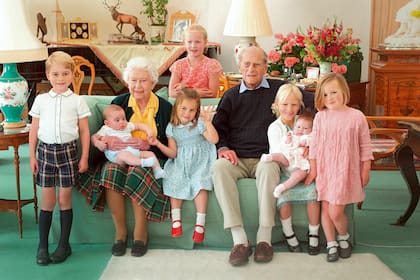 Isabel y Felipe de Edimburgo junto a siete de sus doce bisnietos en una imagen tierna captada en 2018 por Kate, actual princesa de Gales. De izquierda a derecha, el príncipe George, el príncipe Louis en brazos de la Reina, Savannah Phillips (de pie, detrás del sillón), la princesa Charlotte, Isla Phillips con la pequeña Lena Tindall, y Mia Tindall.