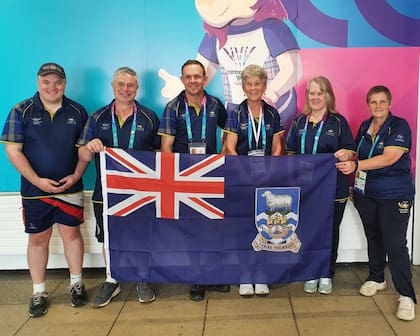 Isleños posan en un evento deportivo con la bandera de las islas Malvinas después del partido del Mundial Argentina-Inglaterra