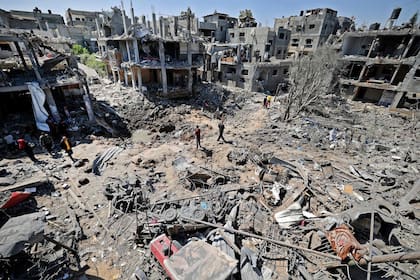 Palestinos evalúan el daño causado por los ataques aéreos israelíes en Beit Hanun, en el norte de la Franja de Gaza