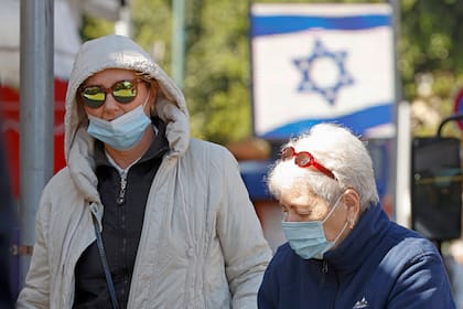 Israelíes, con máscaras protectoras, hacen compras en el mercado central de la ciudad costera de Netanya