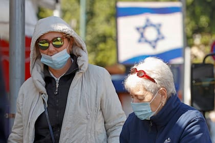 Israelíes, con máscaras protectoras debido a la pandemia de coronavirus, compran en el mercado central de la ciudad costera de Netanya en Israel el 27 de diciembre de 2020, antes de un tercer cierre