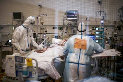 Los trabajadores médicos atienden a un paciente en una sala de aislamiento del coronavirus en el Centro Médico Ziv en la ciudad de Safed en el norte de Israel el 24 de diciembre de 2020