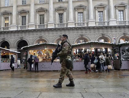 Italia. Un soldado frente al mercado en la plaza del Duomo, Milán