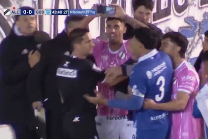 Iván Zafarana, de All Boys, le muestra el celular a Nicolás Lamolina mientras le dice: "Fue afuera"; el árbitro había cobrado penal para Godoy Cruz, pero modificó el fallo