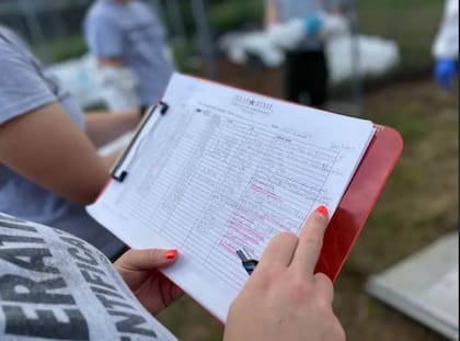 Ivanna Robledo verifica los datos de uno de los cadáveres en un informe en las instalaciones de Operation Identification en San Marcos, Texas, el 24 de abril de 2024