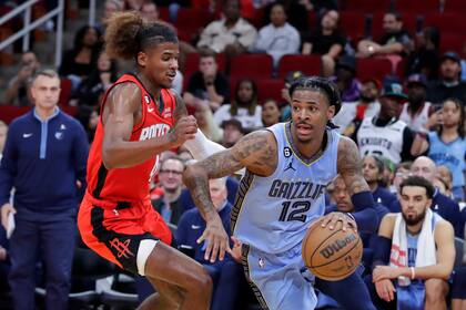 Ja Morant (12), de los Grizzlies de Memphis, trata de superar a Jalen Green, de los Rockets de Houston, durante la segunda mitad del juego de baloncesto de la NBA, el viernes 21 de octubre de 2022, en Houston. (AP Photo/Michael Wyke)