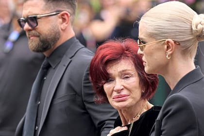 Jack, Sharon y Kelly Osbourne depositan flores en el banco del puente Black Sabbath en Broad Street, Birmingham, mientras el cuerpo del músico era trasladado de regreso a su ciudad natal para el cortejo fúnebre
