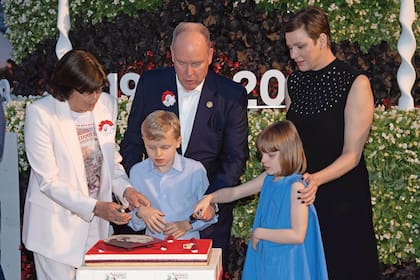 Jacques y Gabriella cortan la torta con la ayuda de sus padres y su tía Estefanía.