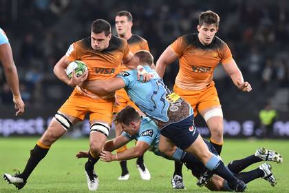Jaguares Guido Petti (L) is tackled by Waratahs player Tom Robertson (C) during the Super Rugby match between Australias NSW Waratahs and Argentinas Jaguares at BankWest Stadium in Sydney on May 25, 2019. (Photo by PETER PARKS / AFP)