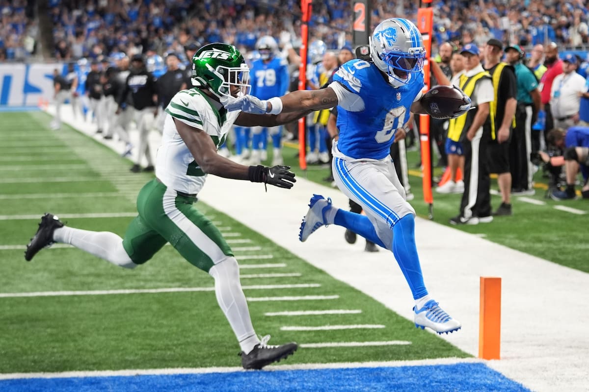Jahmyr Gibbs (0), de los Lions de Detroit, corre para un touchdown superando a Brandon Stephens, de