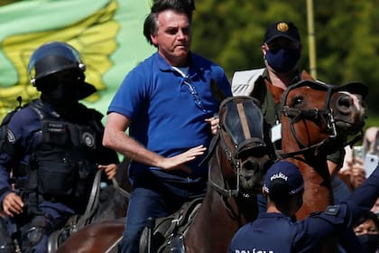 Jair Bolsonaro montó ayer un caballo de la policía para saludar a sus partidarios en Brasilia