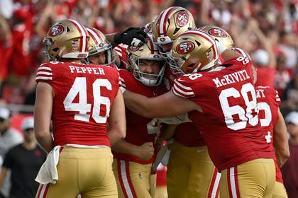 Jake Moody, al centro, de los 49ers de San Francisco, celebra con sus compañeros de equipo después de patear el gol de campo de la victoria en los últimos instantes del partido de la NFL en contra de los Buccaneers de Tampa Bay, en Tampa, Florida, el domingo 10 de noviembre de 2024. (AP Foto/Jason Behnken)