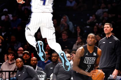 Jalen Suggs (4), del Magic de Orlando, pega un gran salto en labor defensiva frente a Shake Milton (7), de los Nets de Brooklyn, durante la segunda mitad del juego de baloncesto de la NBA Cup, el viernes 29 de noviembre de 2024, en Nueva York. (AP Foto/Noah K. Murray)