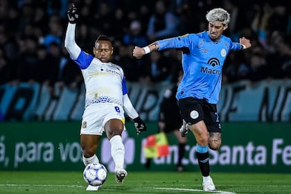 Jaminton Campaz, que jugó el Mundial para Colombia, se esfuerza ante la marca de Emiliano Rigoni, uno de los referentes del campeón Belgrano; Rosario Central ahora se medirá con Racing y luego visitará a River