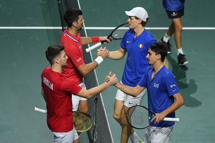 Jannik Sinner (con visera) y Lorenzo Sonego saludan a Novak Djokovic y Momir Kecmanovic después del triunfo en el dobles, que selló la victoria de Italia ante Serbia