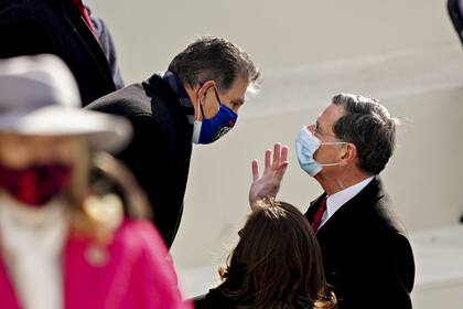 January 20, 2021 - Washington, DC, United States: Senator Joe Manchin, a Democrat from West Virginia, left, and Senator John Barrasso, a Republican from Wyoming, wear protective masks while talking during the 59th presidential inauguration in Washington, D.C., U.S., on Wednesday, Jan. 20, 2021. Biden will propose a broad immigration overhaul on his first day as president, including a shortened pathway to U.S. citizenship for undocumented migrants - a complete reversal from Donald Trump's immigration restrictions and crackdowns, but one that faces major roadblocks in Congress. (Kevin Dietsch/CNP/Polaris)