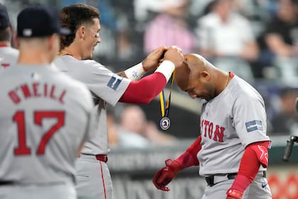 Jarren Duran (izquierda) de los Medias Rojas de Boston cuelga una medalla a su compañero Jamie Westbrook tras el jonrón de Westbrook ante los Medias Blancas de Chicago, el jueves 6 de junio de 202, en Chicago. (AP Photo/Charles Rex Arbogast)