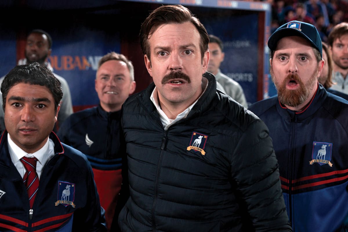 Jason Sudeikis personifica a Ted Lasso, acompañado aquí por Brendan Hunt (Coach Beard).