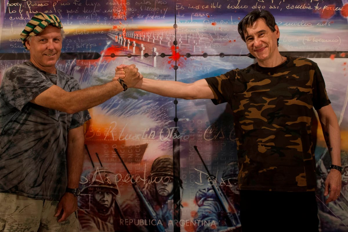Javier de Aubeyzon, artista, y Martín Otaño, excombatiente de Malvinas; de fondo, el óleo "Carta a un amigo"