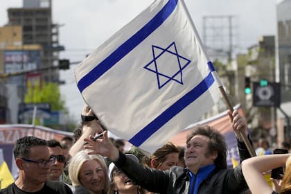Javier Milei, de la Libertad Avanza, sostiene una bandera israelí durante su caravana por Lomas de Zamora, el lunes 16 de octubre de 2023