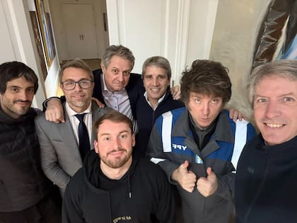 Javier Milei en Olivos con su mameluco de YPF rodeado del ministro Luis Caputo y sus seguidores. 2025
