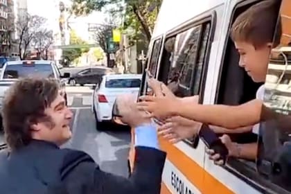Javier Milei rumbo a Olivos se bajó del auto y saludó a varios niños que viajaban en un transporte escolar
