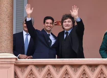 Javier Milei saluda desde el balcón de la Casa Rosada junto a su vocero Adrián Ravier