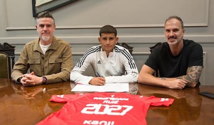Javier Ruiz, el día de la firma de su contrato con Independiente hasta 2027; lo flanquean dos dirigentes, el tesorero Christian Urreli y el secretario general Daniel Seoane