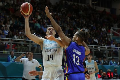 Javier Saiz maniobra ante un rival venezolano en la final del básquetbol por el oro