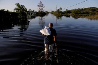 Jean Chatelier camina por una calle inundada luego del huracán Irma, en Fort Myers, Florida, el 12 de septiembre del 2017. (AP foto/David Goldman)