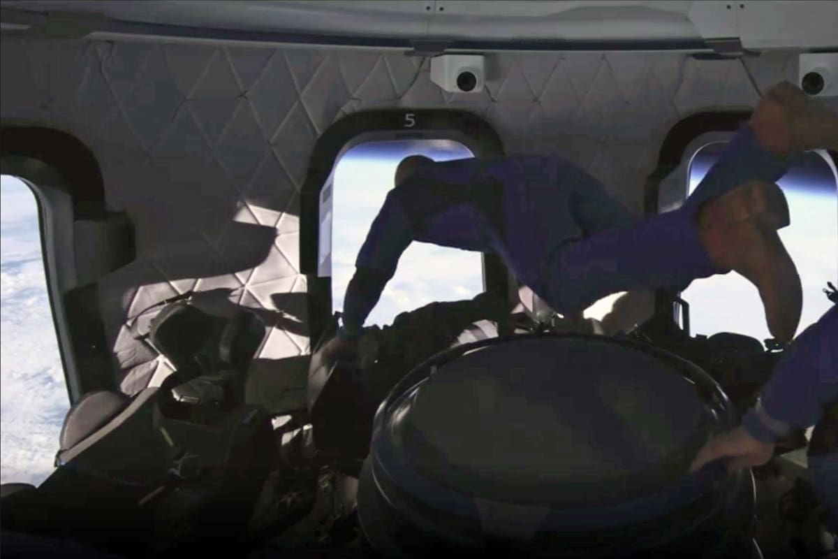 Jeff Bezos frente al mirador de la cápsula que lo llevó al espacio impulsado por el cohete reutilizable New Shepard