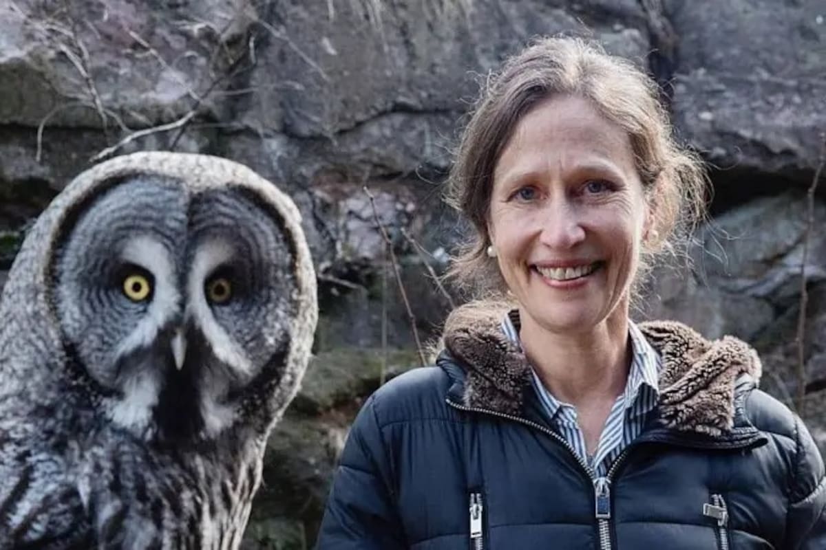 Jennifer Ackerman junto a un gran búho gris (Strix nebulosa)