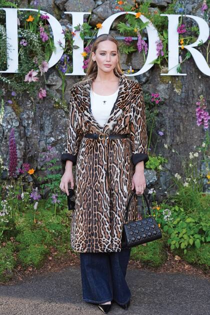 Jennifer Lawrence lució un tapado en estampado de leopardo, ceñido con un cinturón fino de cuero, top blanco y jeans anchos.