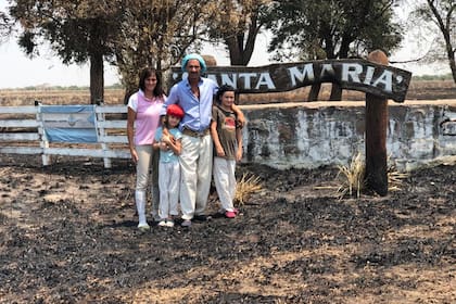 Jessica Prada y Víctor Rey junto a sus dos hijos en la entrada del campo quemado el viernes pasado