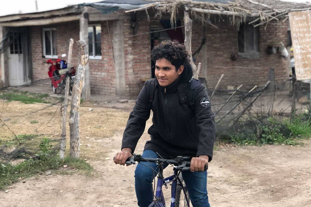 Jesús subiéndose a la bicicleta para ir a la escuela. Está necesitando una moto para poder recorrer más rápido los 14 kilómetros que lo separan de su escuela