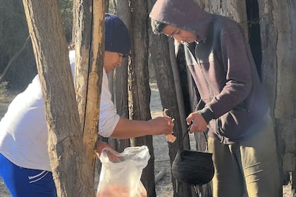 Jesús y su mamá ponen a calentar la grasa para hacer tortas fritas