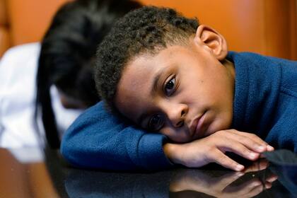 Jhaimarion, un niño de 10 años, reacciona mientras su madre Krystal Archie habla con un reportero de  Associated Press en Chicago, el 23 de septiembre de 2021. Miles de menores de edad sufren violentas interacciones con la policía en EEUU, siendo algunos incluso apuntados con pistolas, revela una investigación de la AP (Foto AP/Nam Y. Huh)