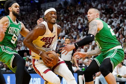Jimmy Butler (22), del Heat de Miami, conduce el balón entre Derrick White (9) y Daniel Theis (27), de los Celtics de Boston, durante la segunda mitad del Juego 1 de las finales de la Conferencia Este de la NBA, el martes 17 de mayo de 2022, en Miami. (AP Foto/Lynne Sladky)