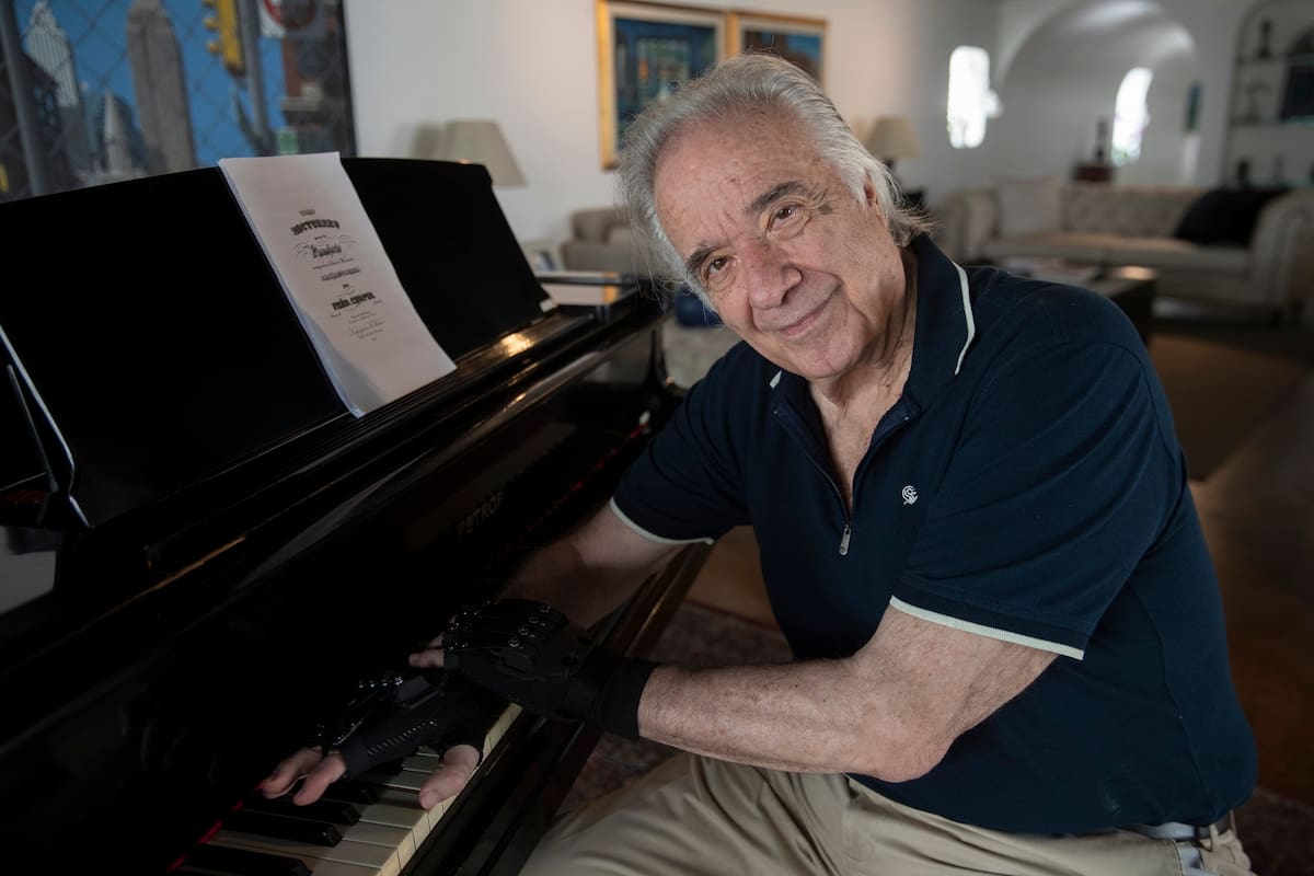 Joäo Carlos Martins junto a su piano Petrof; puede volver a tocar gracias a unos guantes que lo ayudan en la digitación