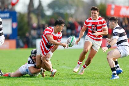 Joaquín Díaz Luzzi, apertura de Alumni, hace un pase en el contacto; el 10 fue bueno con la pelota en ataque y también en las patadas y, con 22 puntos, golpeó a un CASI ahora errante en el Top 12 de URBA.