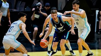 Joaquín Rodríguez, figura de Uruguay con 20 puntos, se escapa entre Gonzalo Corbalán y Gonzalo Bressan.