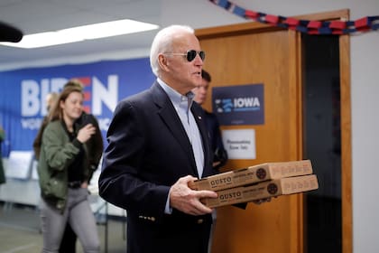 Joe Biden llevó pizza a sus voluntarios, ayer, durante el caucus de Iowa