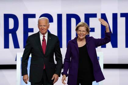 Joe Biden y Elizabeth Warren saludan al público en el debate demócrata de octubre