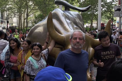 Joe Goldman en la calle junto a la estatua de un toro.