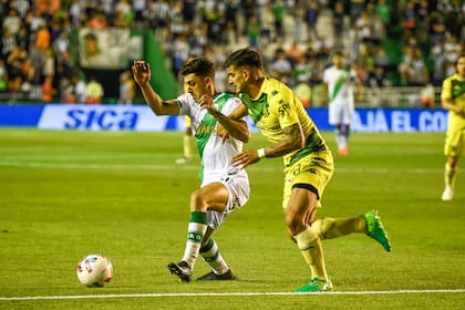 Joel Soñora, volante ofensivo de Banfield, intenta progresar en ataque ante la marca de Román