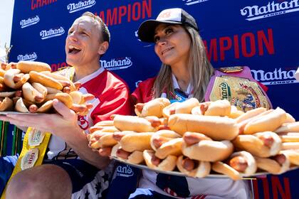 Joey Chestnut y Miki Sudo posan con 63 y 40 "hot dogs", respectivamente, tras ganar el concurso de perros calientes que organiza Nathan's Famous por el 4 de Julio en Coney Island, el lunes 4 de julio de 2022, en Nueva York. (AP Foto/Julia Nikhinson)